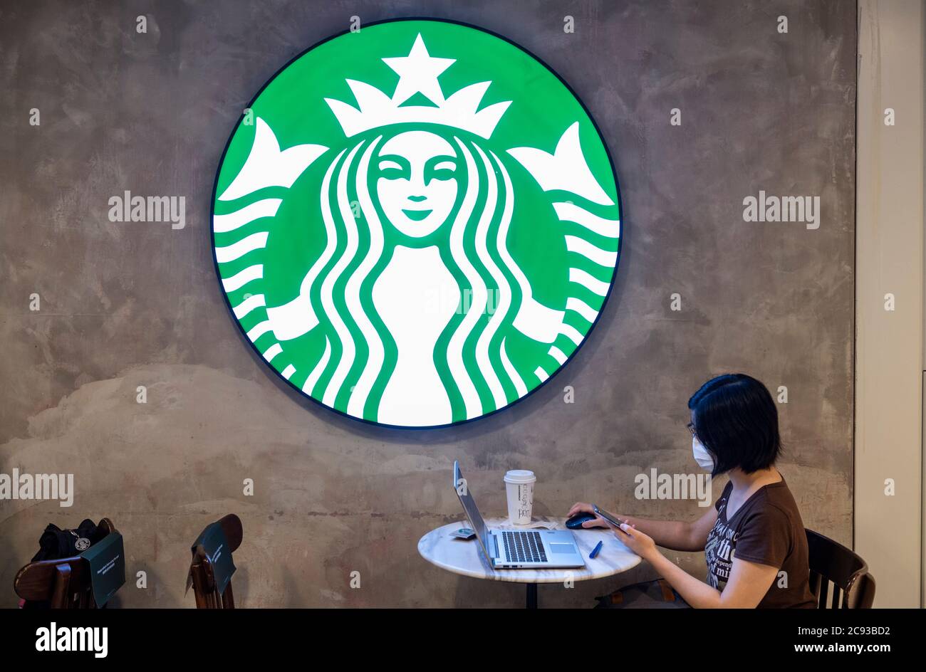 Hongkong, China. Juli 2020. Ein Gast sitzt in einem amerikanischen multinationalen Starbucks Coffee Store und Logo in Hongkong. Kredit: SOPA Images Limited/Alamy Live Nachrichten Stockfoto