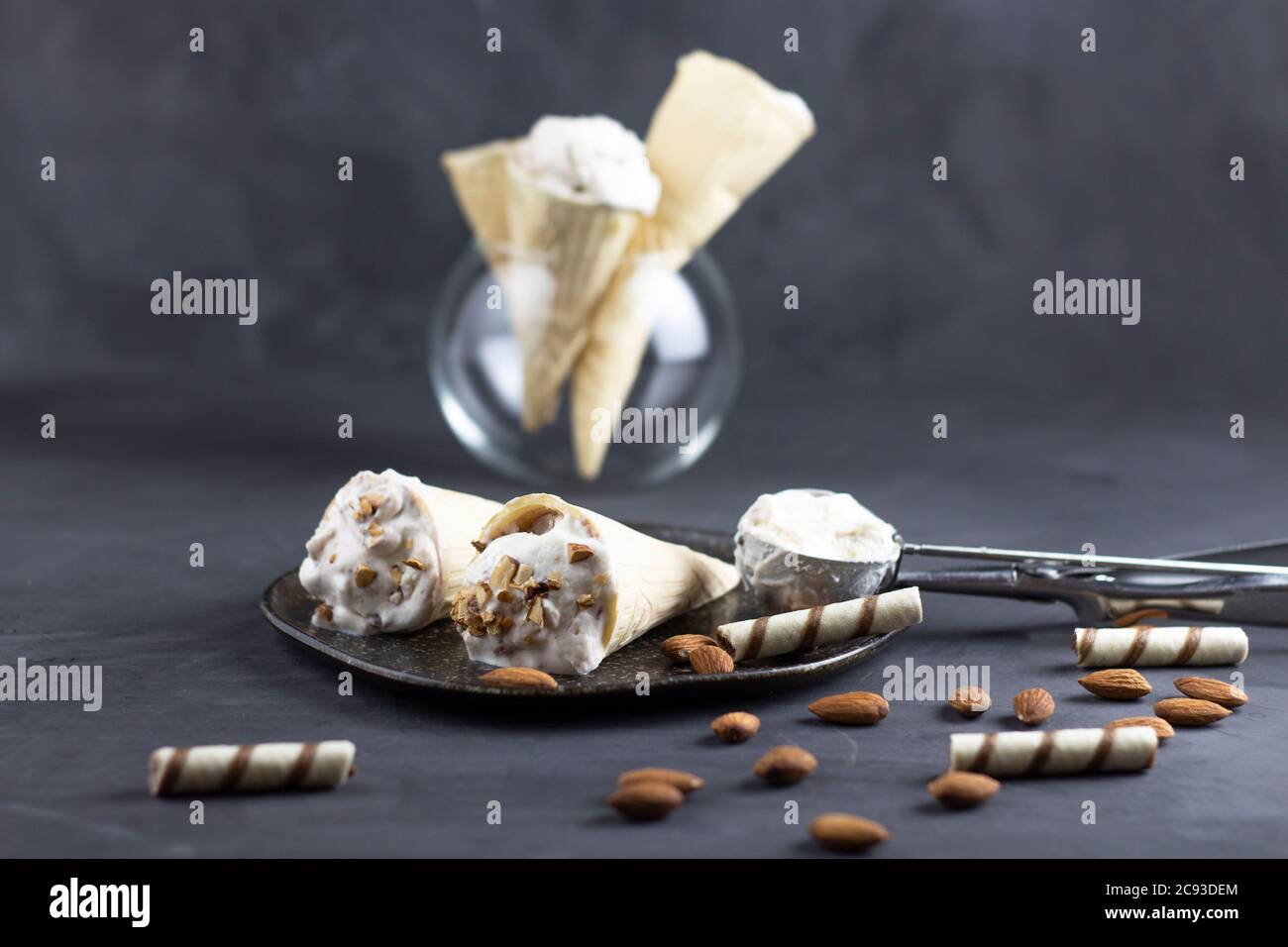 Eis Hintergrund in Zapfen. Frisches Eis zum Nachtisch. Mandeleis und Waffeleisen auf grauem Hintergrund. Copyspace Stockfoto