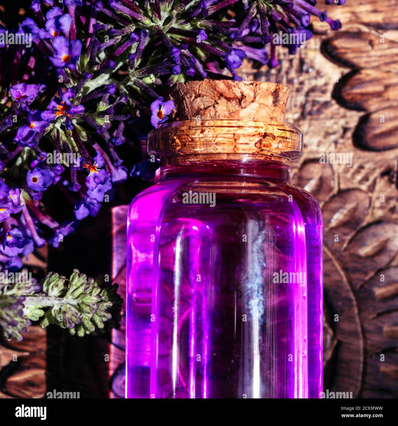 Violetter Trank auf Holzoberfläche mit violetten Blüten Stockfoto