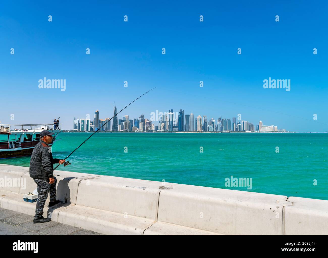 Lokale Mann Angeln vor der Skyline der West Bay Central Business District, die Corniche, Doha, Katar, Naher Osten Stockfoto