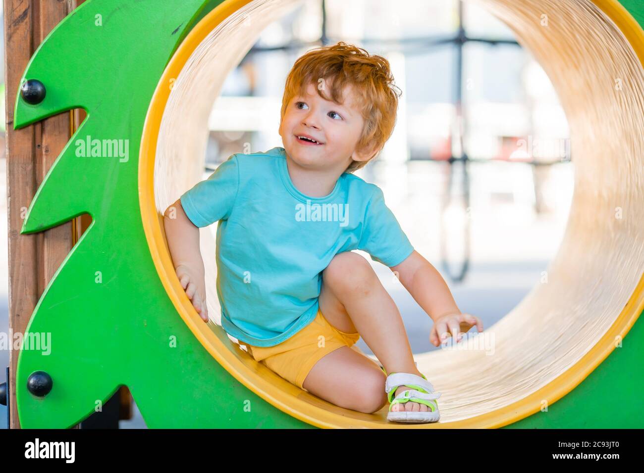 Kleiner Junge von zwei Jahren spielt im Sommer in einer Kinderstadt. Kinderlebensstil Stockfoto