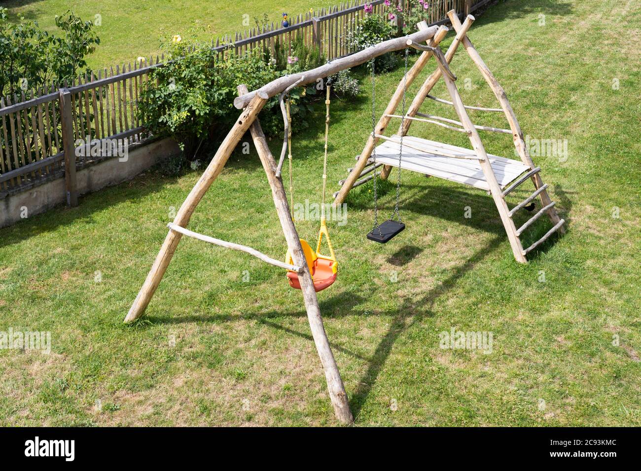 Ein umweltfreundlicher, selbstgemachter Holzkletterrahmen und Schaukeln für Kinder in einem Garten in Österreich Stockfoto