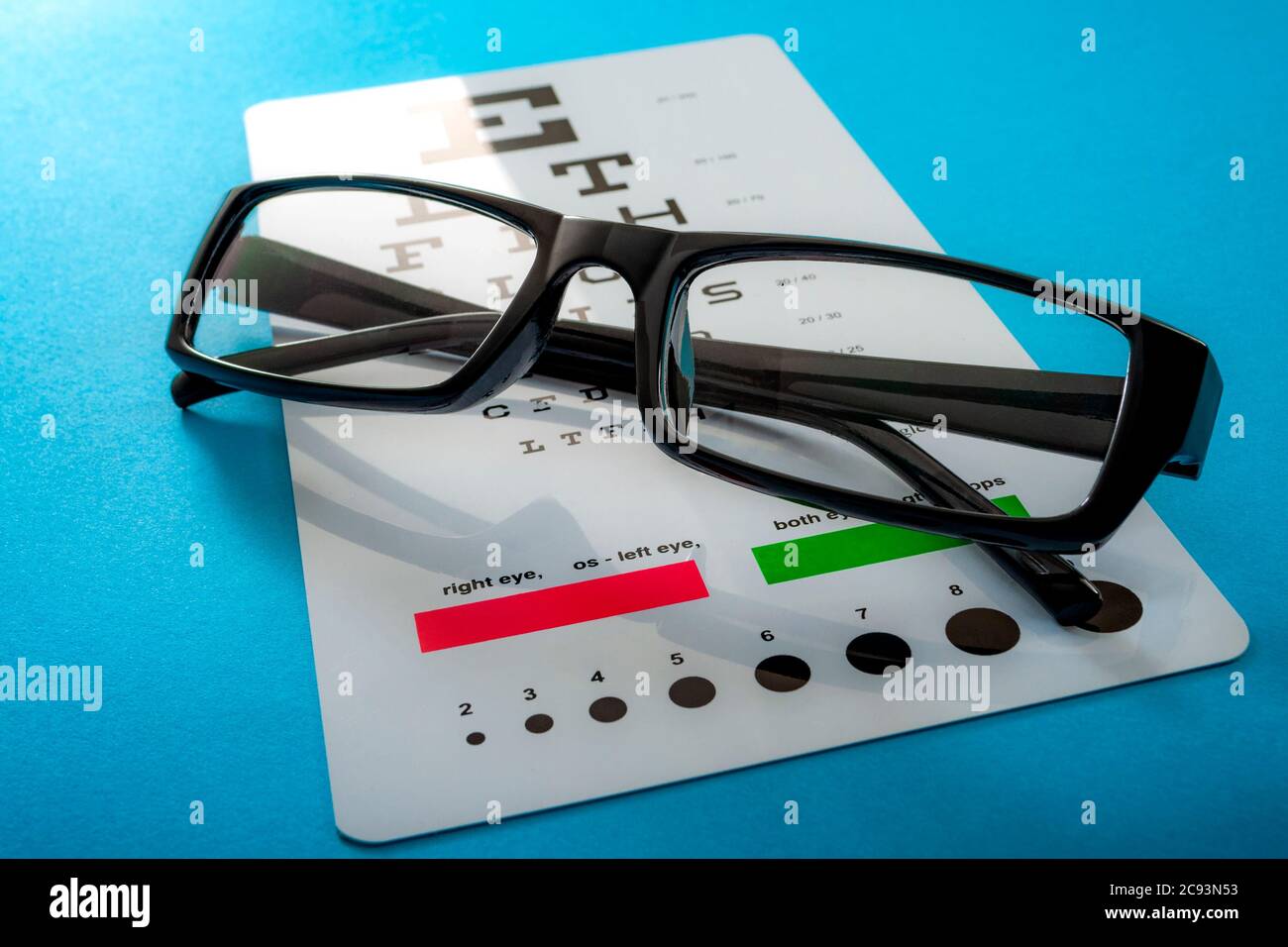 Augenuntersuchung, gesunde Augen und ophthalmologisches Konzept mit einem Paar Sehbrillen und einer auf blauem Hintergrund isolierten Augenkarte Stockfoto