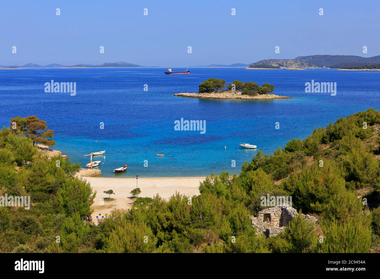 Schöner Strand mit klarem blauem Wasser und einer eigenen unbewohnten Insel in Primosten (Gespanschaft Sibenik-Knin), Kroatien Stockfoto