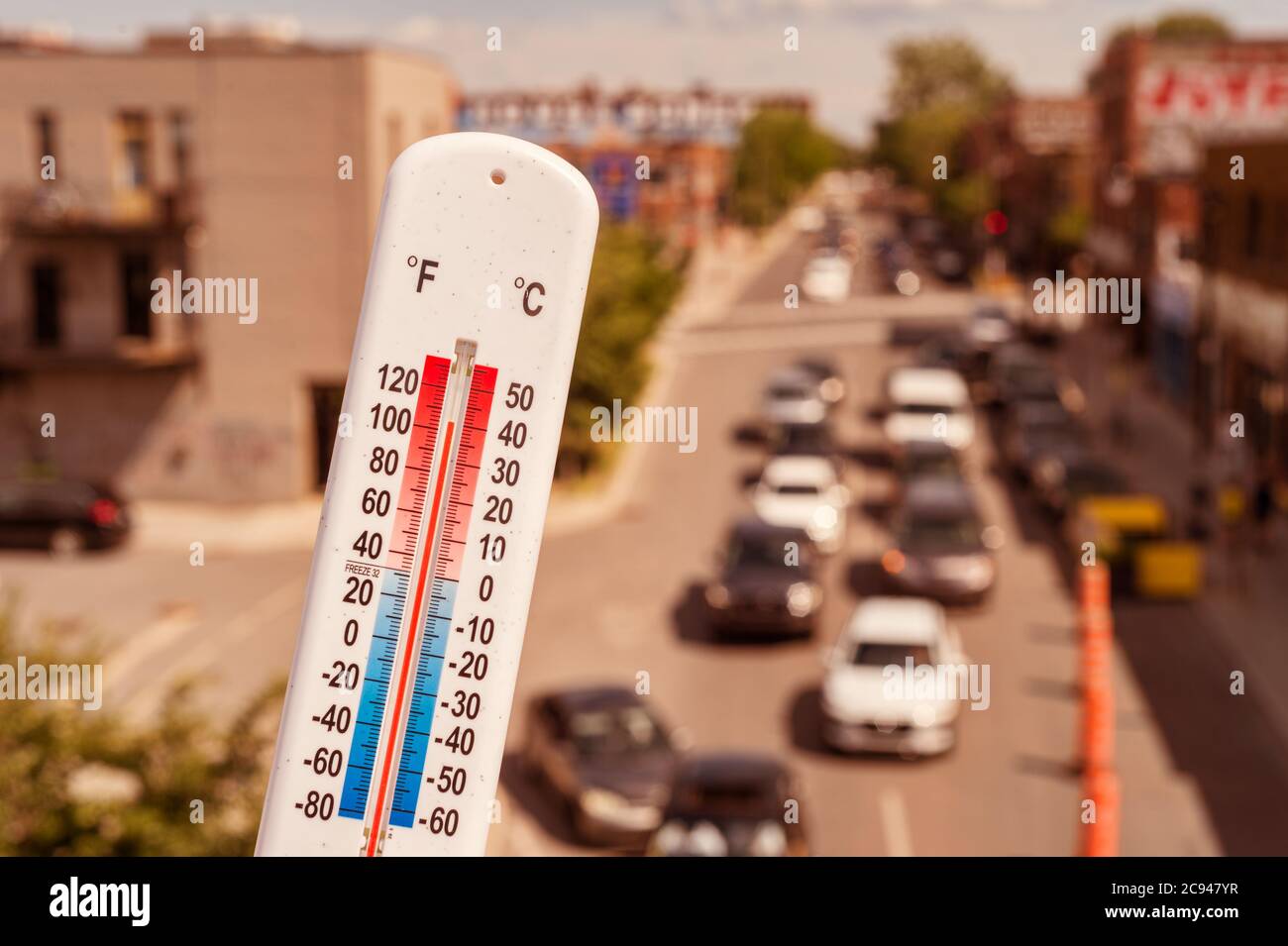 Thermometer vor dem Auto und Verkehr während der Hitzewelle in Montreal. Stockfoto