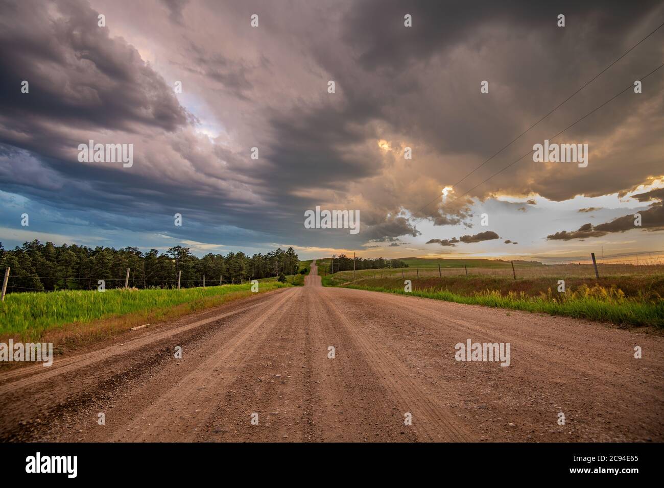 Bild einer klassischen Backcountry Schotterstraße im Mittleren Westen mit einer Perspektive der Straße, die ins nichts führt. Stockfoto