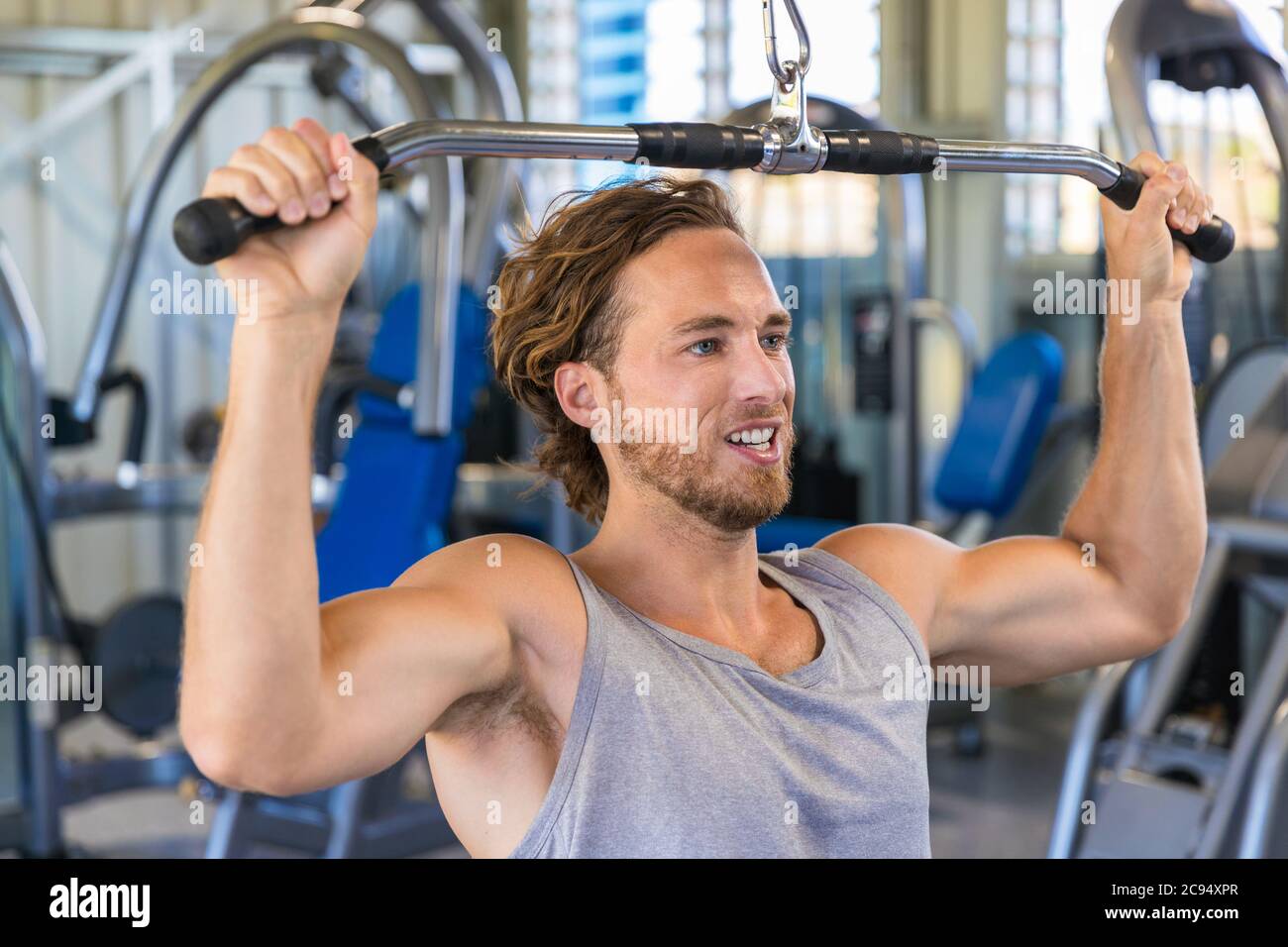 Schulter herunterziehen Maschine. Fitness-Mann, der im Fitnessstudio ein Ausziehtraining ausarbeitet. Oberkörperkraftübung für den oberen Rücken Stockfoto