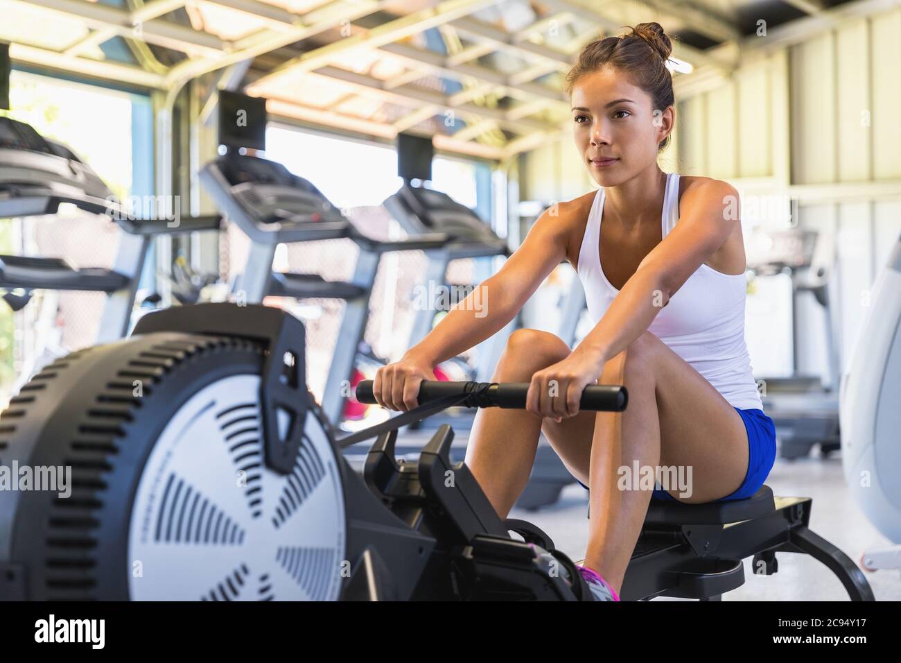 Workout Frau Crosstraining Cardio-Training mit Rudergerät in  Fitness-Studio. Asiatische Mädchen arbeiten aus Stockfotografie - Alamy