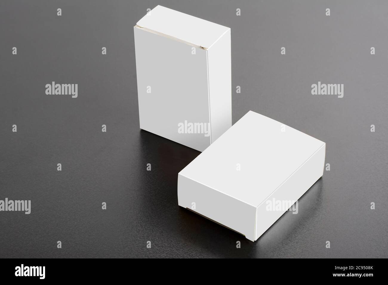 Zwei Pillboxen Pakete auf dunklem Hintergrund, editierbare Mock-up-Serie bereit für Ihr Design, Auswahlpfad enthalten. Stockfoto