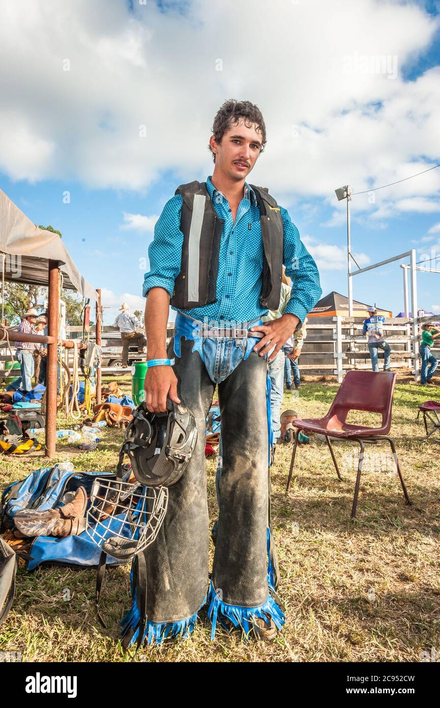 Ein Cowboy steht für ein Porträt, Helm in der Hand, während er sich mental auf seinen nächsten Bullen-Ritt beim Mt Garnet Rodeo in Queensland, Australien, vorbereitet. Stockfoto