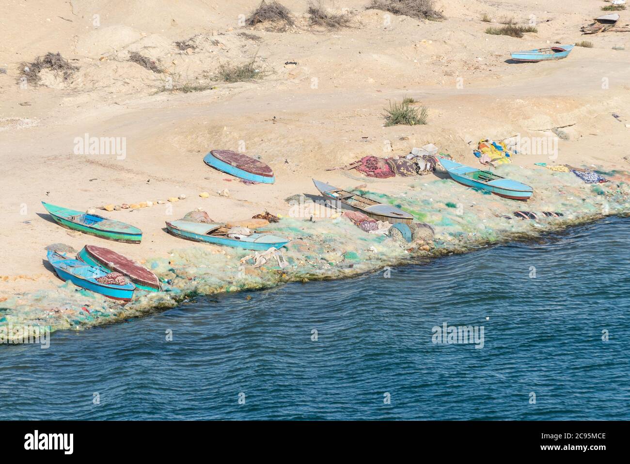 El Qantara, Ägypten - 14. November 2019: Fischerboote und Netze liegen am Ufer des Suezkanals in Ägypten, Afrika. Stockfoto