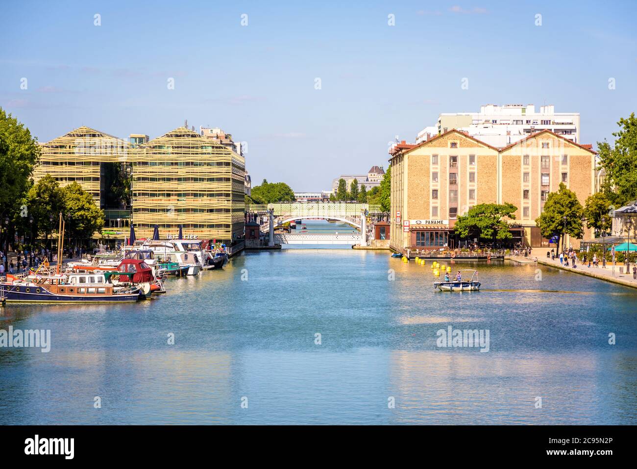 Nahaufnahme der ehemaligen Lagerhäuser auf beiden Seiten des Beckens La Villette und der Liftbrücke der Rue de Crimée dazwischen in Paris, Frankreich. Stockfoto