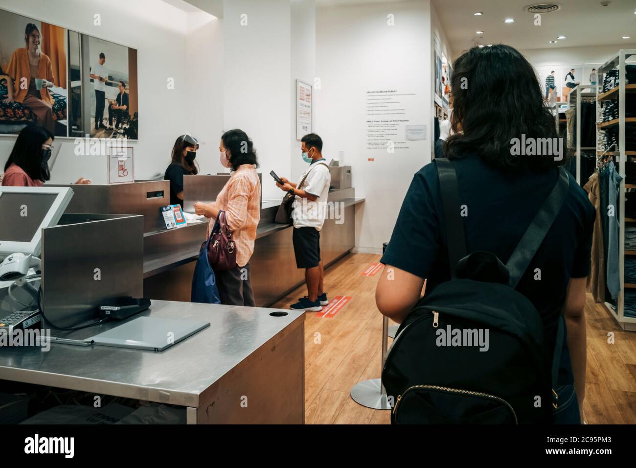 Bangkok, Thailand - 3. August 2020 : Asiatische Kunden in der Warteschlange bezahlen Kleidung an der Theke in Bekleidungsgeschäft in covid-19 Pandemie Krise. Stockfoto
