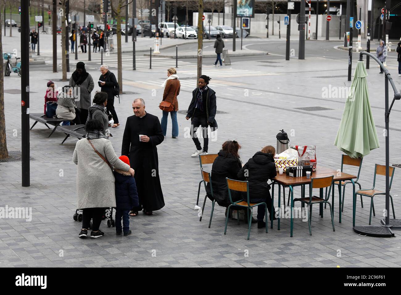 Katholischer Priester begrüßt Gemeindemitglieder vor seiner Kirche in Paris, Frankreich. Stockfoto