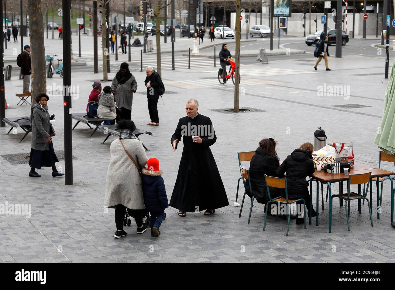 Katholischer Priester begrüßt Gemeindemitglieder vor seiner Kirche in Paris, Frankreich. Stockfoto