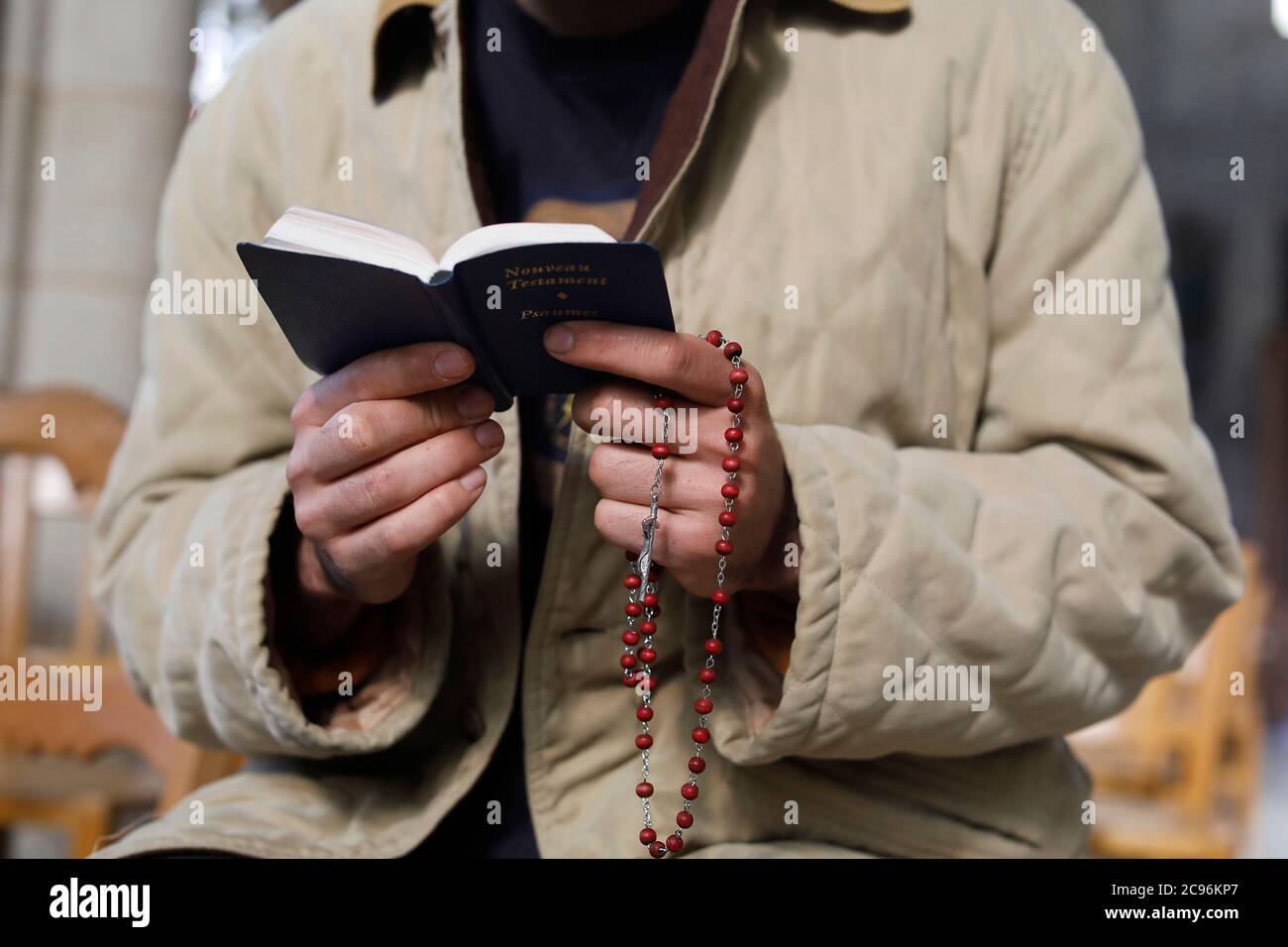 Junger Mann beim Lesen des Evangeliums in der Kirche, Beaumont-le-Roger, Frankreich. Stockfoto