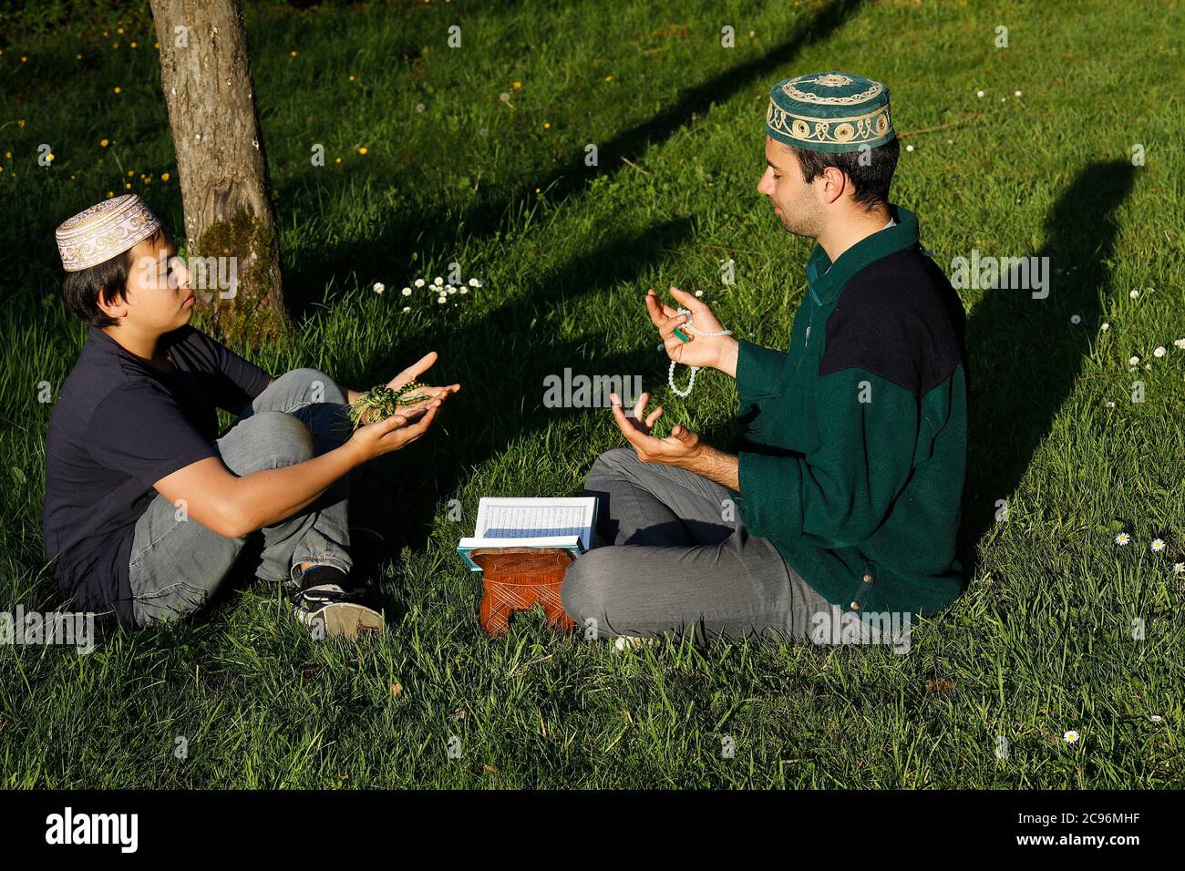 Junge muslime beten in einem Garten in Frankreich. Stockfoto