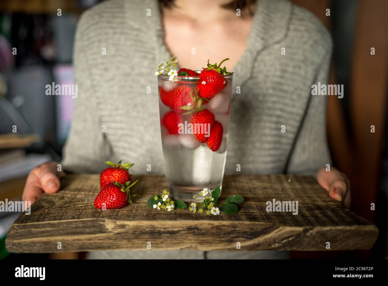 Glas mit einem im Sommer gekühlten klaren kohlensäurehaltigen Getränk, Eis und Erdbeeren. Erfrischende Kühle Stockfoto