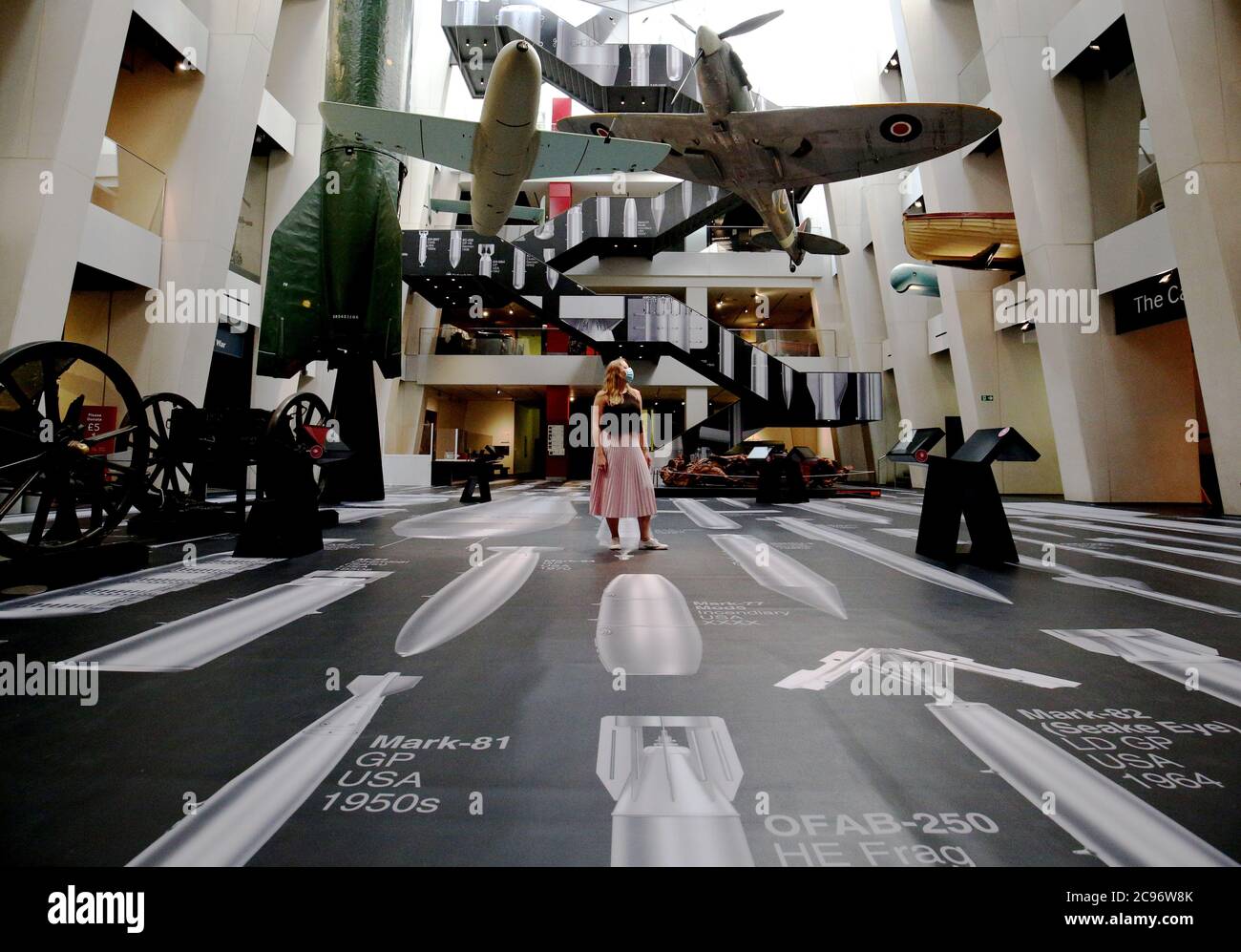 Ein Mitarbeiter des Imperial war Museum steht auf einem Teil der Oberfläche von Ai Weiweis 'Geschichte der Bomben' während einer Fotoausstellung für das neue Werk des chinesischen Künstlers, die im Imperial war Museum in London zu sehen ist. Das Kunstwerk zeigt 50 maßstabsgemaßte Bomben vom Ersten Weltkrieg bis in die Gegenwart und deckt die Böden und Wände des IWM-Atriums auf einer Fläche von über 1,000 Quadratmetern ab. Stockfoto