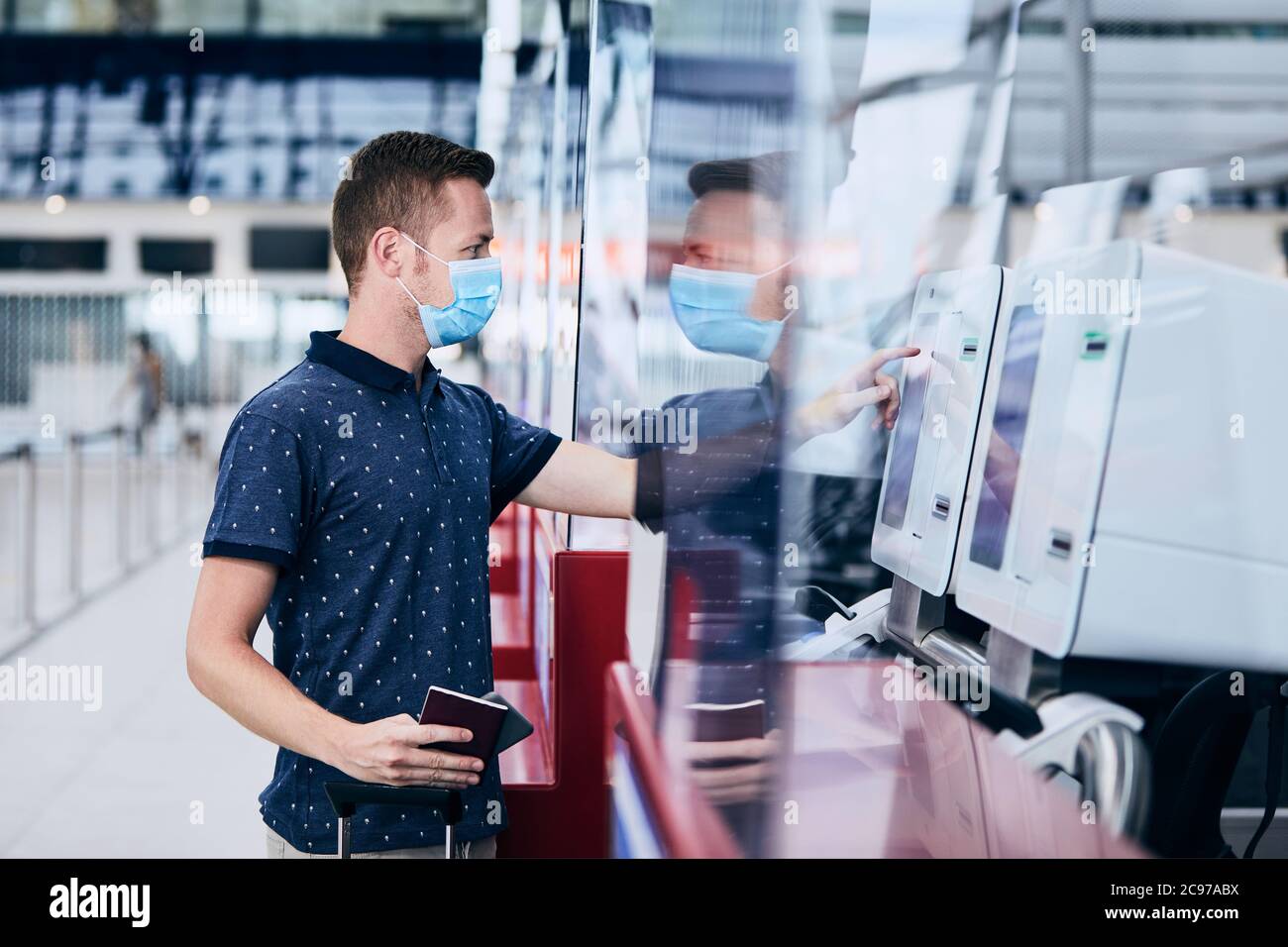 Mann mit Gesichtsmaske beim Check-in am Flughafen. Themen neue normale, Coronavirus und persönlichen Schutz. Stockfoto