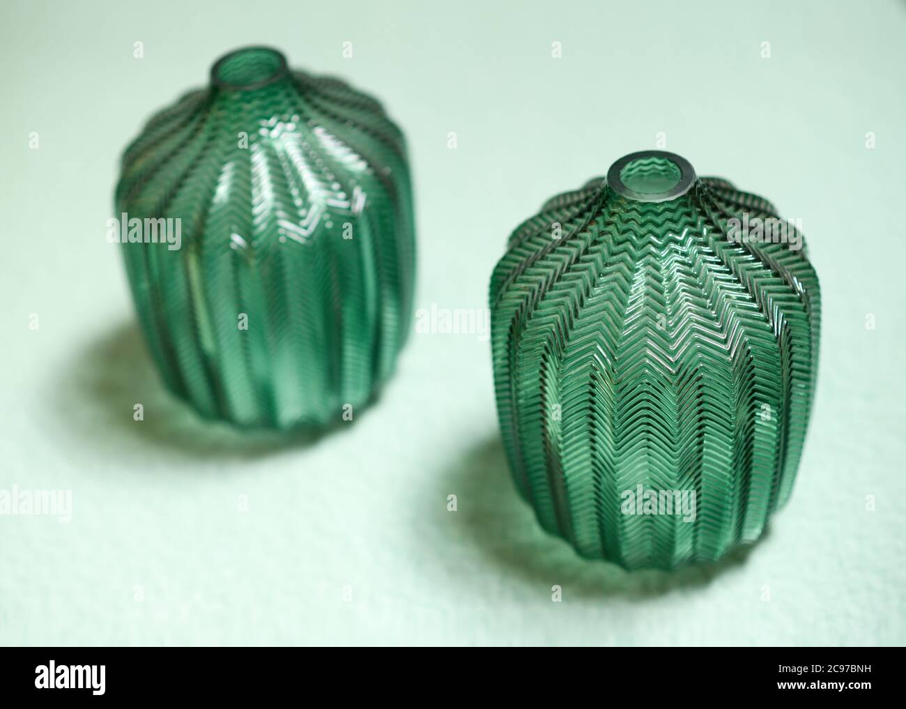 Passendes Paar grüne Design oder Kunst Glas Gefäße mit dekorativem Muster in einem hohen Winkel Ansicht mit Fokus auf eins Stockfoto