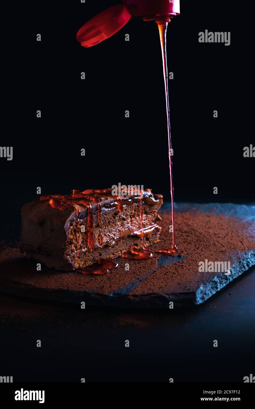Stück Schokolade hausgemachten Kuchen mit Nüssen und Aprikosengelee in einem Steinteller Stockfoto