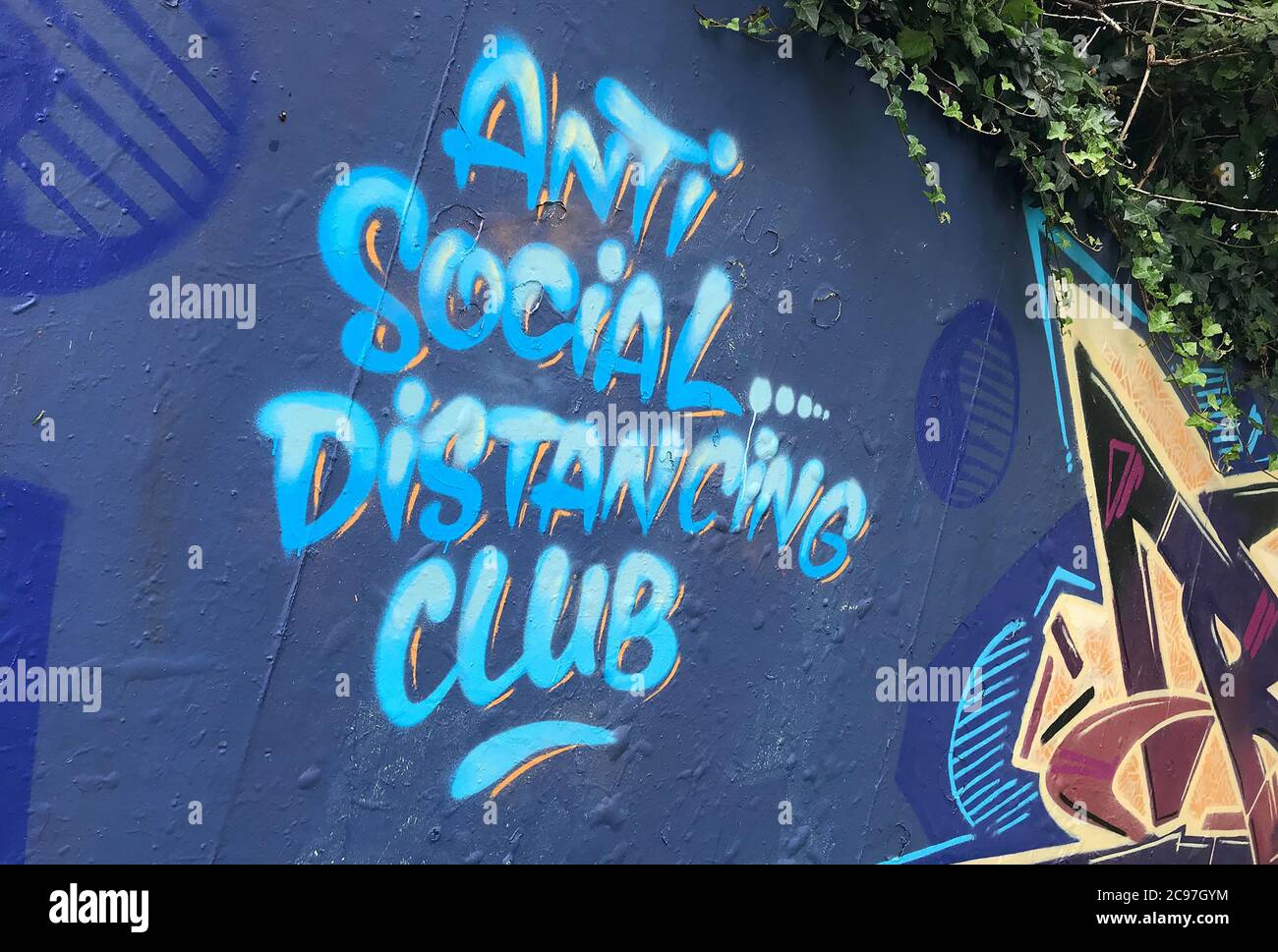 Topische Graffiti gesprüht auf eine Graffiti-Wand in Swansea, Großbritannien sagen "Anti Social Distancing Club". Stockfoto