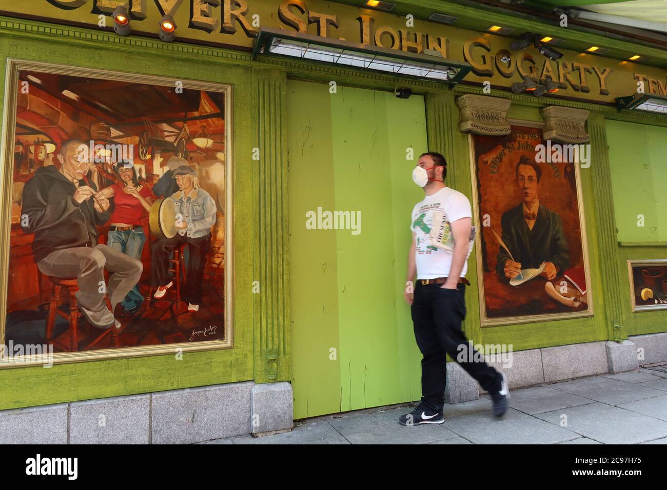 Der Mann geht an der geschlossenen vorbei und geht in den Oliver St John Gogarty Pub, der eine Gesichtsmaske trägt, weil 19 Lockdown, Temple Bar, Dubin, Irland, Stockfoto