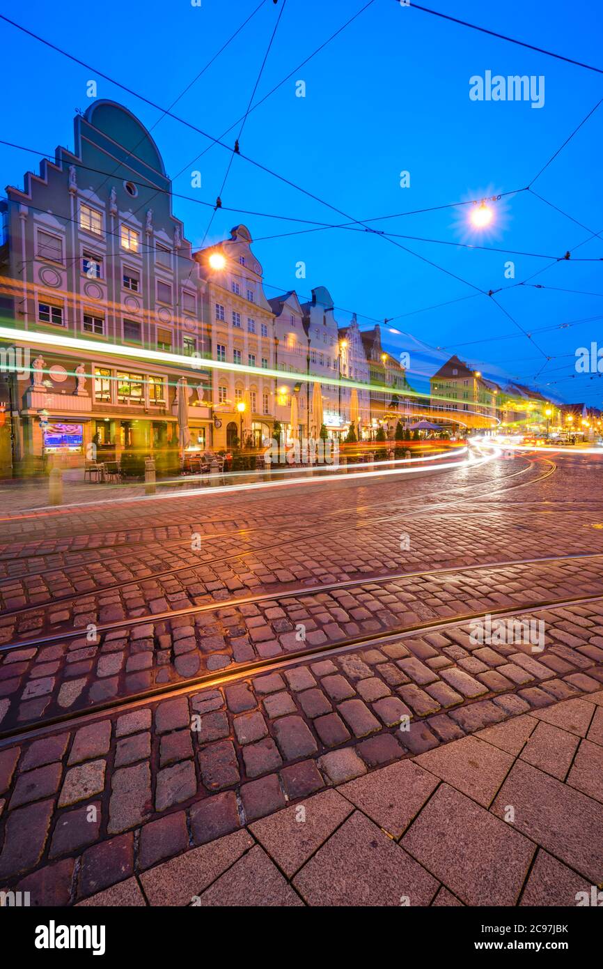 Augsburg, Deutschland Altstadt Stadtbild von Straßenautos vorbei an Cafés und Geschäften am Moritzplatz am Abend. Stockfoto