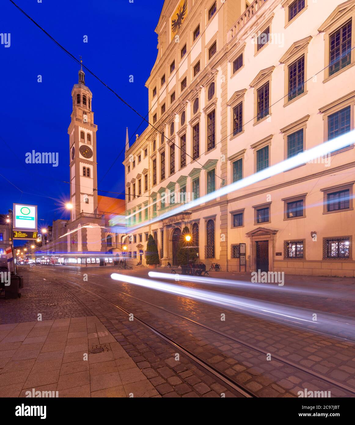 Augsburg, Deutschland am Rathausplatz als Straßenauto bei Nacht vorbeifährt. Stockfoto