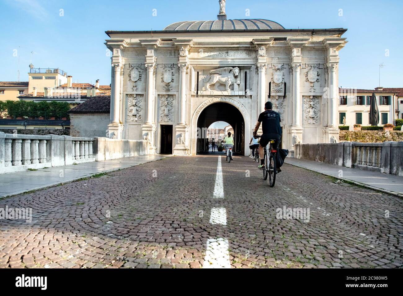 Porta San Tommaso mit Touristen auf dem Fahrrad auf der Straße in der Stadt Treviso Venedig, Venetien Italien Stockfoto