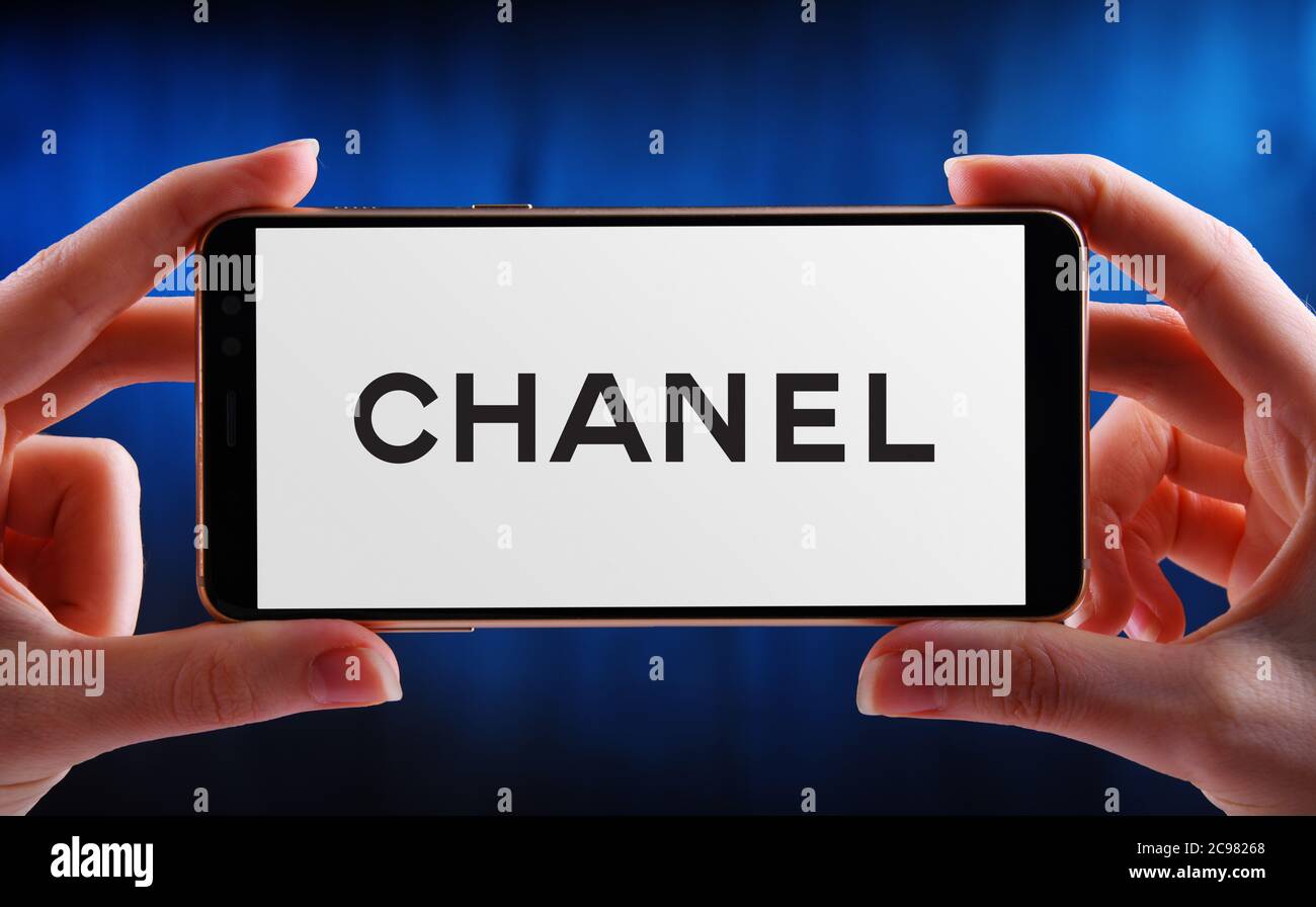 POZNAN, POL - JUN 12, 2020: Hand halten Smartphone mit Logo von Chanel, ein Luxus-Unternehmen, das sich auf High-Fashion und Ready-made Kleidung, l Stockfoto