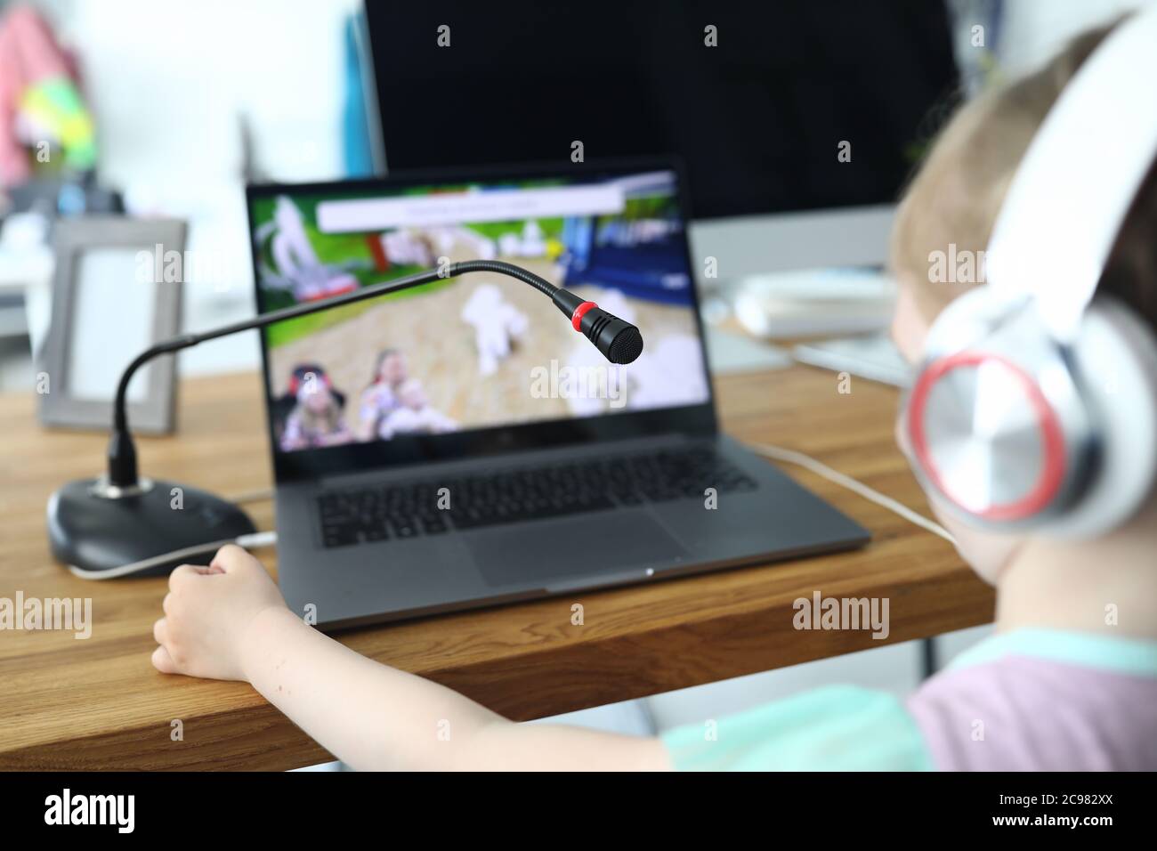 Mädchen, das am Tisch sitzt und ein Video ansieht Stockfoto