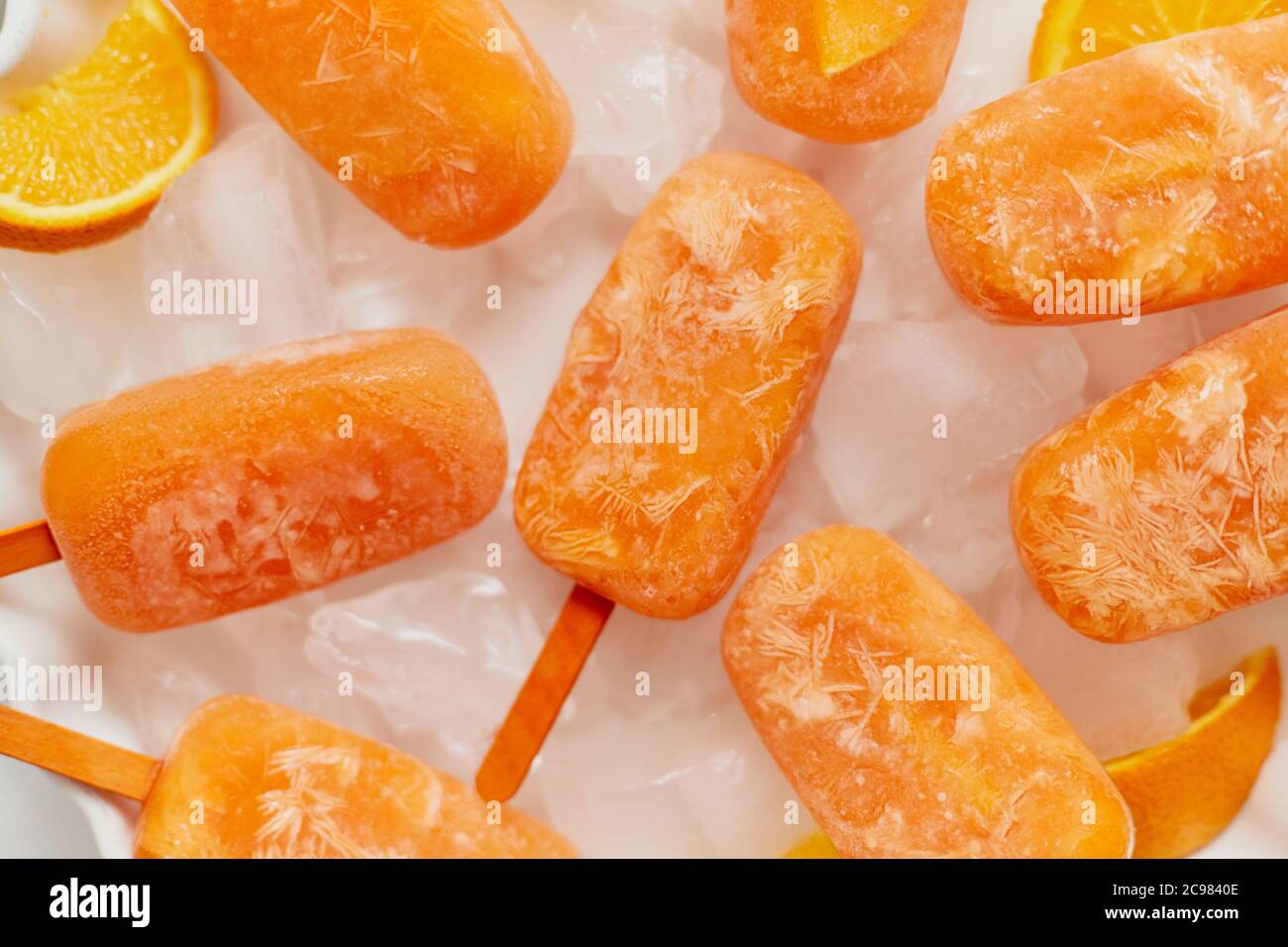 Hausgemachte gefrorene Eis-Eiszapfen mit oragnic frischen Orangen mit Eiswürfeln auf Marmortisch platziert gemacht Stockfoto