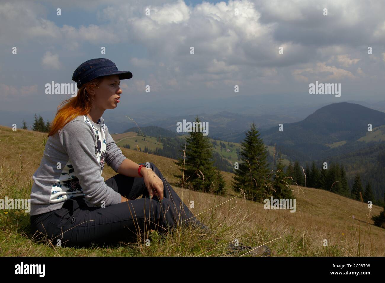 An einem hellen sonnigen Sommertag sitzt Mädchen auf dem Gras in den karpaten Stockfoto