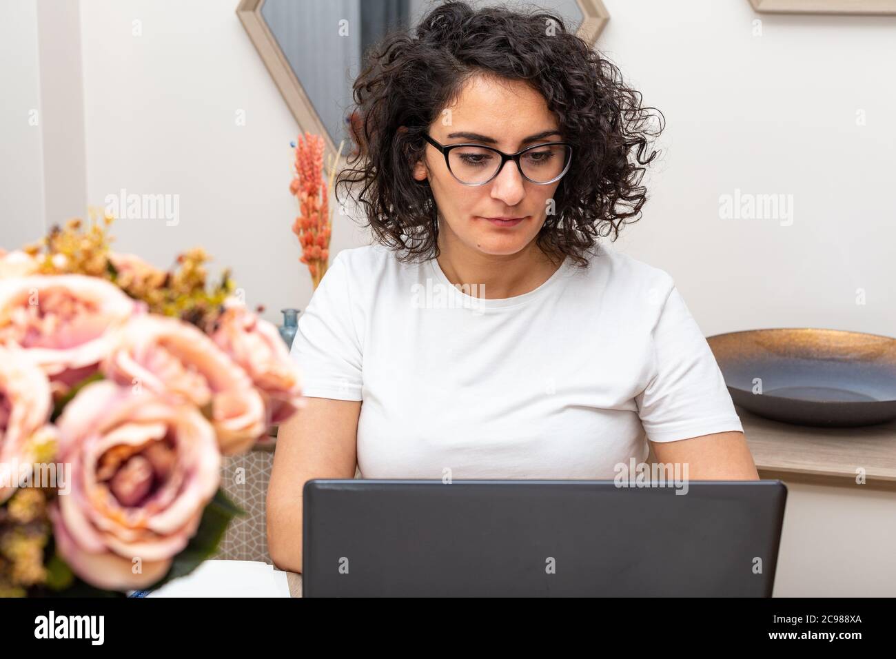 Konzentrierte junge schöne Geschäftsfrau arbeiten auf Laptop in hellen Home Office. Stockfoto