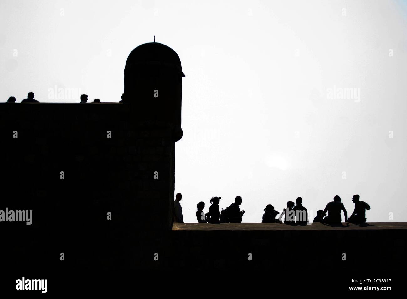 Touristen auf der Spitze der Verteidigungsmauern, die die kroatische Stadt umgeben. Stockfoto