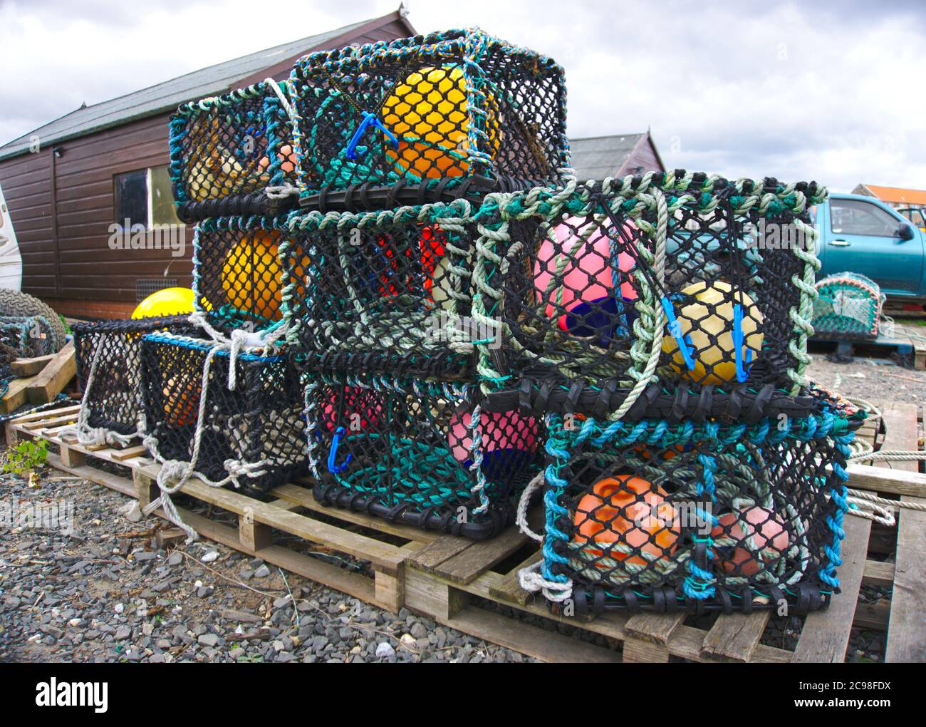 Hummerkrebse und Bojen stapelten sich im Hafen von Holy Island, Lindisfarne, Northumberland. Stockfoto