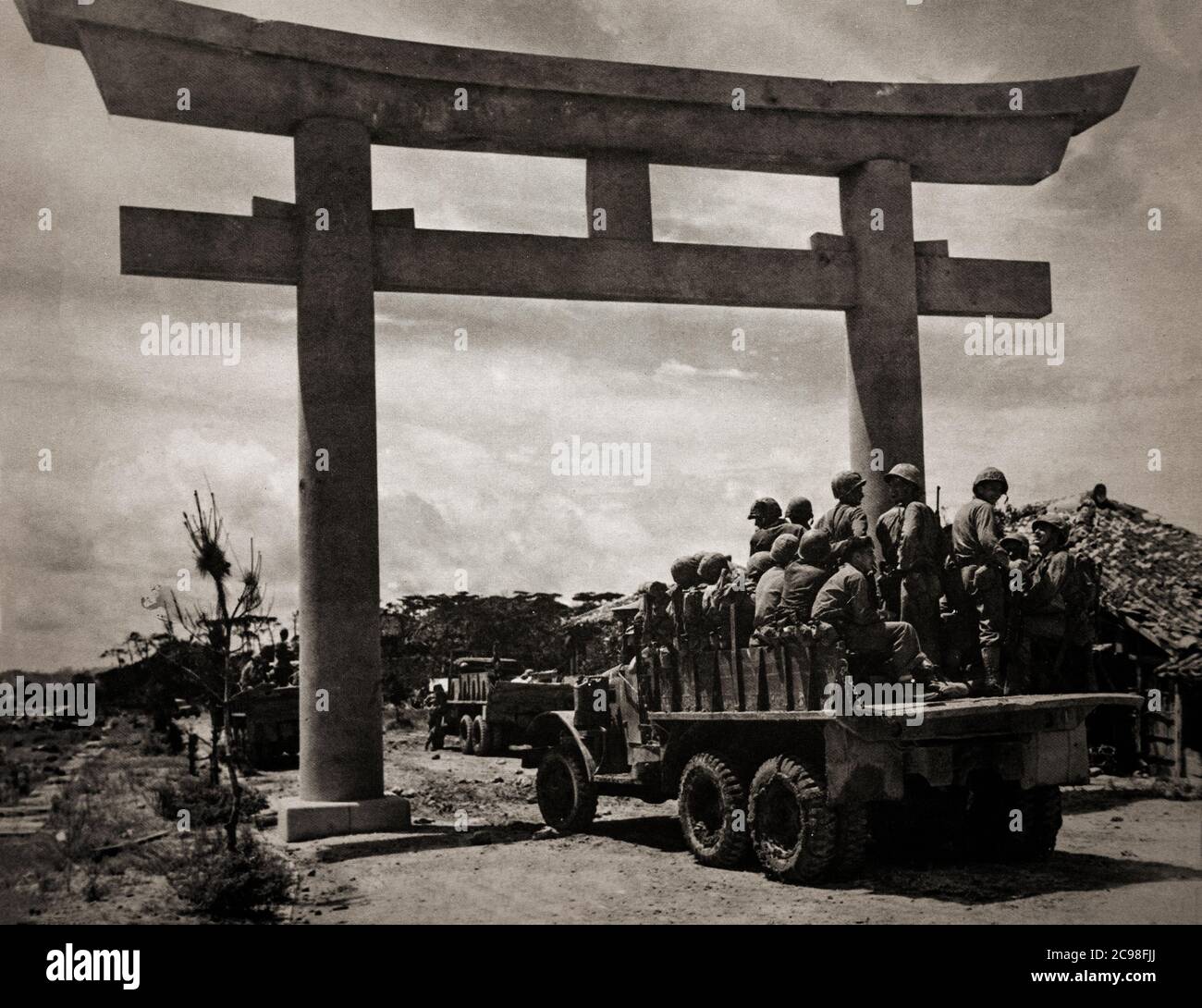 Einheiten des 15. US-Regiments, 6. Marines Division, betreten Naha, Hauptstadt von Okinawa durch eine Torii, ein traditionelles japanisches Tor, als der Krieg im Pazifik im Jahr 1945 zu Ende geht. Stockfoto