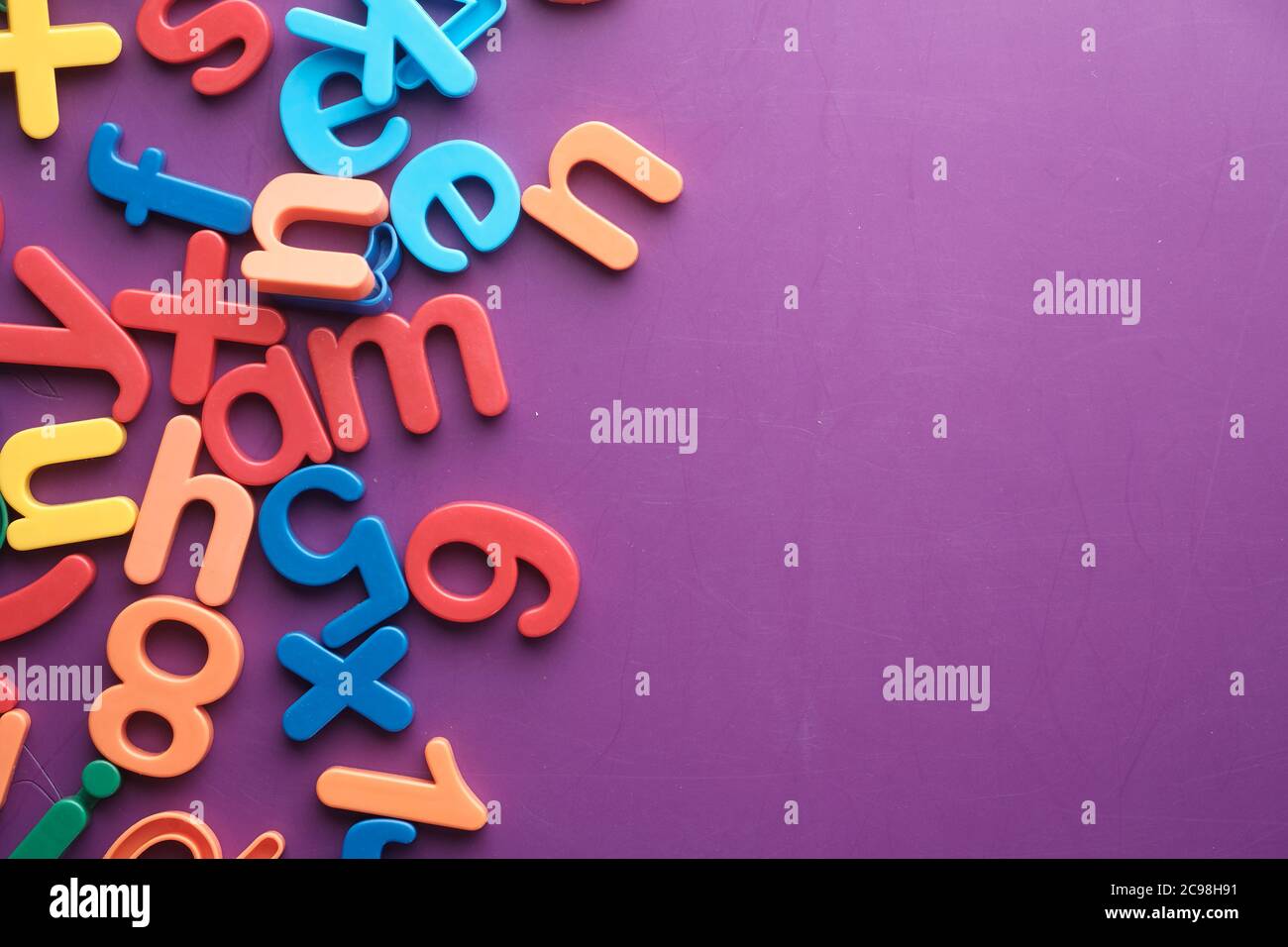 Bunte Kunststoff Buchstaben auf lila Hintergrund, Draufsicht Stockfoto
