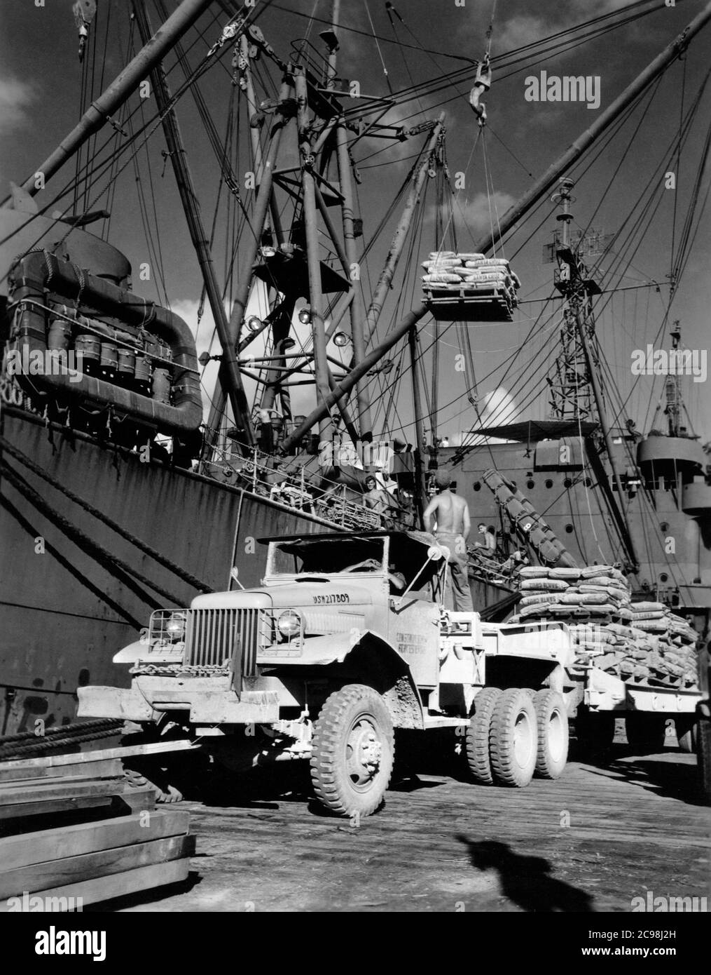 AKA-86 U.S.S. Woodford, Entladen von Fracht in Apre Harbor, Guam, 1945. Zum 75. Jahrestag des V-J Day hat die Consoli Collection vier Fotoessays von U.S. Navy LT. (j.g.) veröffentlicht. Joseph J. Consoli. Die Fotos wurden zwischen Juli und Dezember 1945 auf den Marianen aufgenommen. Sie dokumentieren das Leben der US-Marine vor und nach der japanischen Kapitulation. Stockfoto