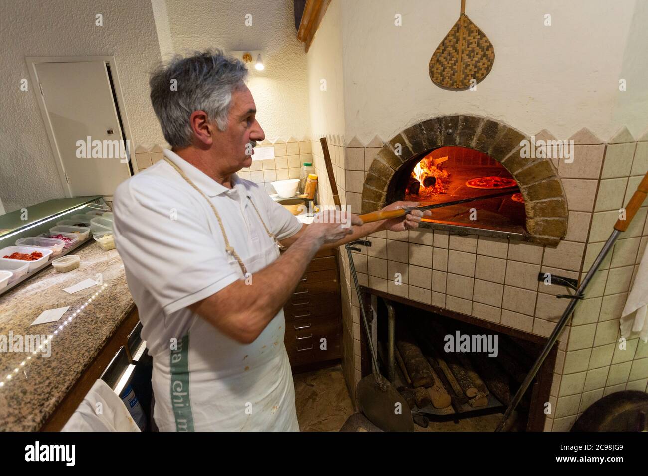 Ein italienischer Koch arbeitet in einem Holzofen in einem Restaurant in  Borgo San Lorenzo, Italien Stockfotografie - Alamy