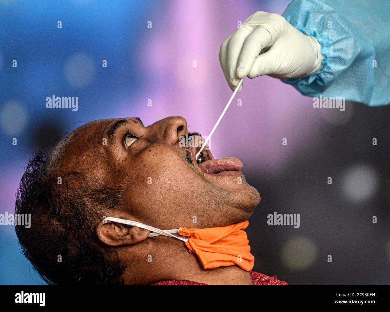 Mumbai, Indien. Juli 2020. Ein Gesundheitshelfer nimmt bei einem medizinischen Screening für das COVID-19 in Mumbai, Indien, am 29. Juli 2020 eine Abstrichprobe durch den Hals eines Mannes. Indiens COVID-19-Tally hat am Mittwoch die 1.5-Millionen-Marke überschritten und erreichte 1,531,669, teilte das Bundesgesundheitsministerium mit. Quelle: Str/Xinhua/Alamy Live News Stockfoto