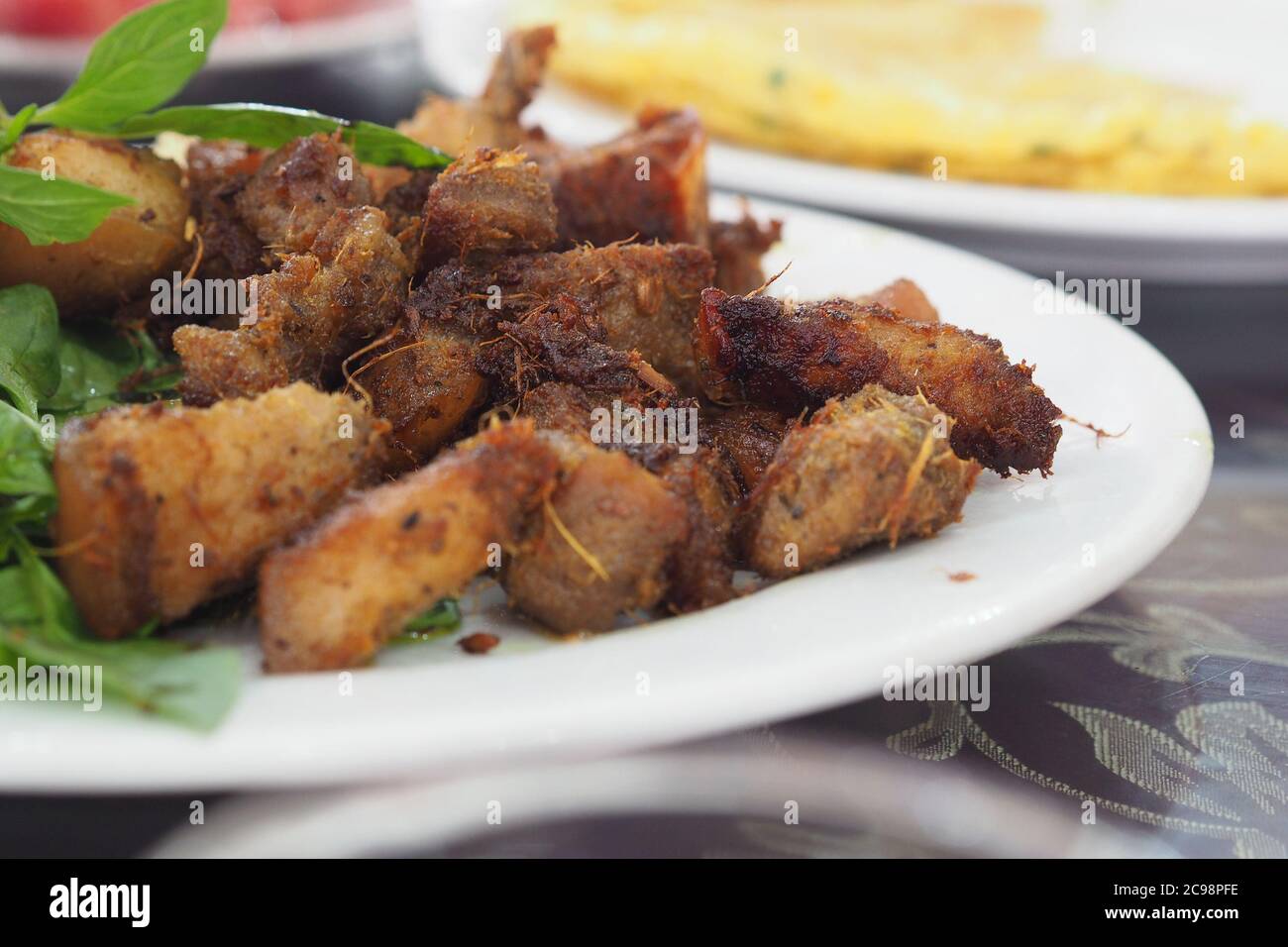 Gebratenes, streifendes Schweinefleisch mit eingelegtem Knoblauch und Basilikumblatt - Vietnamesisches Essen Stockfoto