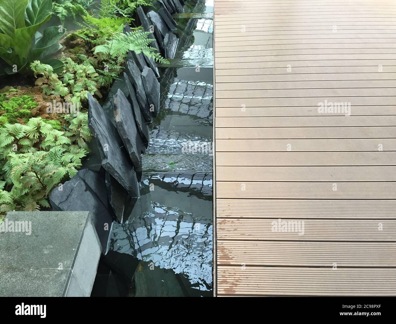 Bodenleiste mit Mini Wasserfall im Garten Stockfoto