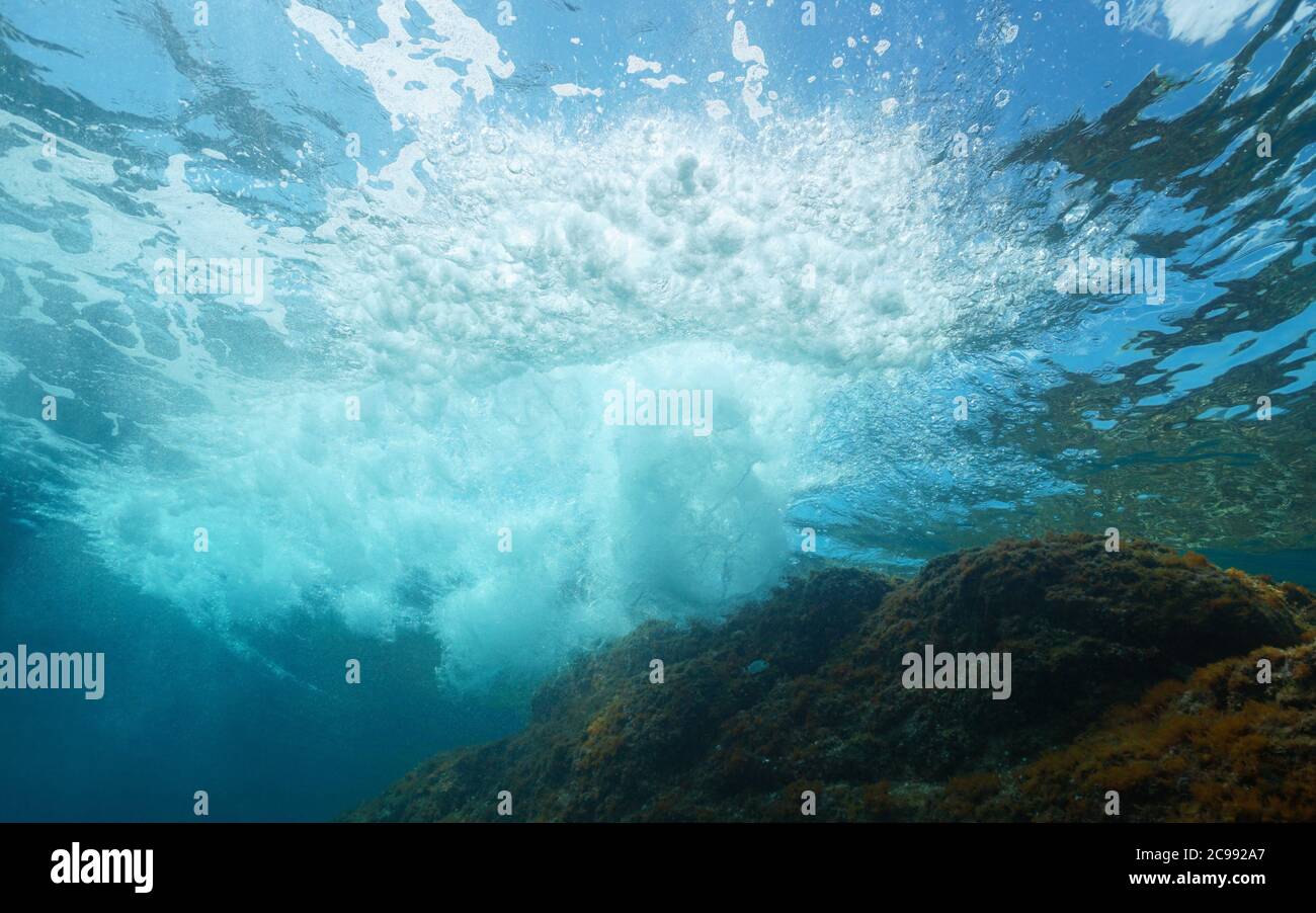 Unterwasserwellen brechen auf Felsen unter der Wasseroberfläche, Mittelmeer Stockfoto