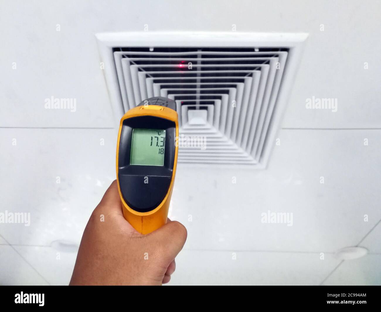 Techniker verwenden ein Infrarot-Thermometer, um die Temperatur der Luftzufuhroberfläche zu überprüfen. Stockfoto