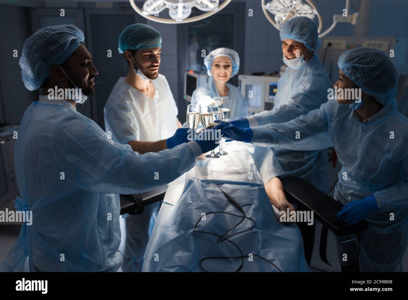 Happy Team verschiedener Chirurgen Toasten mit Sauerstoff Cocktail mit fröhlichen männlichen Kollegen nach der erfolgreichen Operation, das Ende der Arbeit shif. Partne Stockfoto
