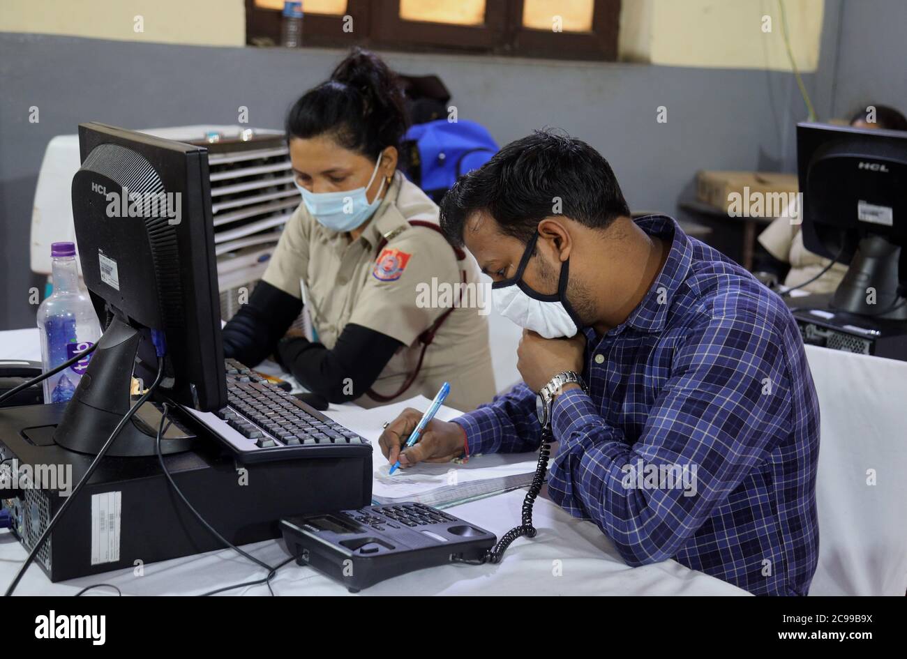 Indische Freiwillige aus Delhi Civil Defence (DCD) tragen Gesichtsmasken und arbeiten im COVID-19 District Central Surveillance and Tele-Medicine Hub, um als kostenloser Hilfsdienst für die COVID-19 Patienten und ihre Familien zu dienen.die Ärzte und Berater aktualisieren Daten, registrieren alle Beschwerden, Der tägliche Gesundheitszustand von COVID-19-Patienten und verhindern, dass sie kritisch werden, bieten medizinische Hilfe, Hygiene und Entfernung von biomedizinischen Abfällen und versorgen sie mit lebenswichtigen Gütern. Dies wurde im Büro des Bezirksrichters des zentralen Bezirks in Daryaganj gestartet. Stockfoto