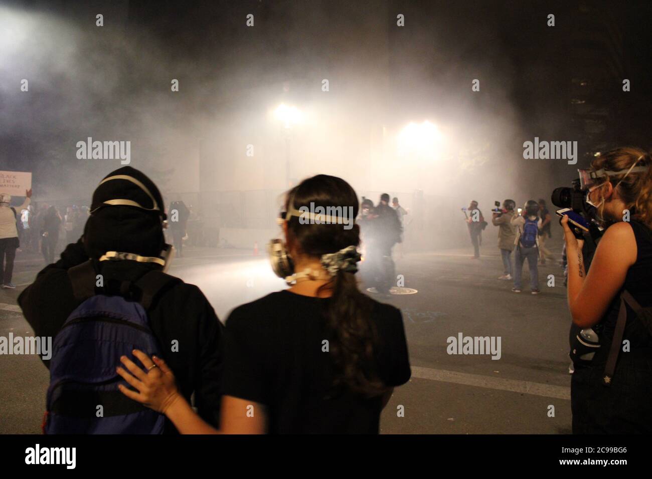 Portland, Oregon, USA. Juli 2020. Portland Proteste: Ein Paar unterstützt sich gegenseitig, da sie und andere friedliche Demonstranten von Bundesagenten mit Tränengas vergast werden.Quelle: Amy Katz/ZUMA Wire/Alamy Live News Stockfoto